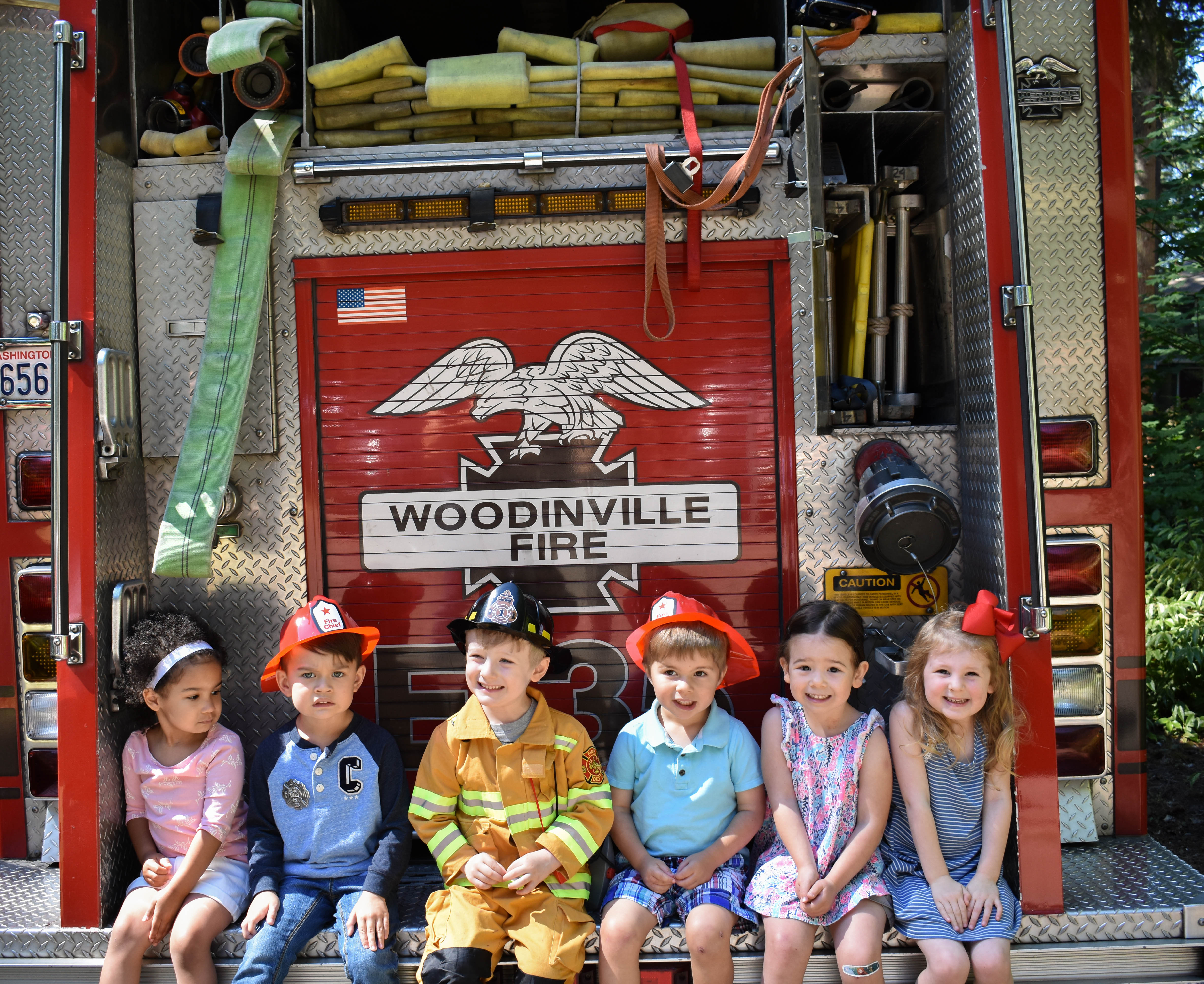 kids sitting on the back of a firetruck at Rescue Vehicles Party from Allison Carter Celebrates