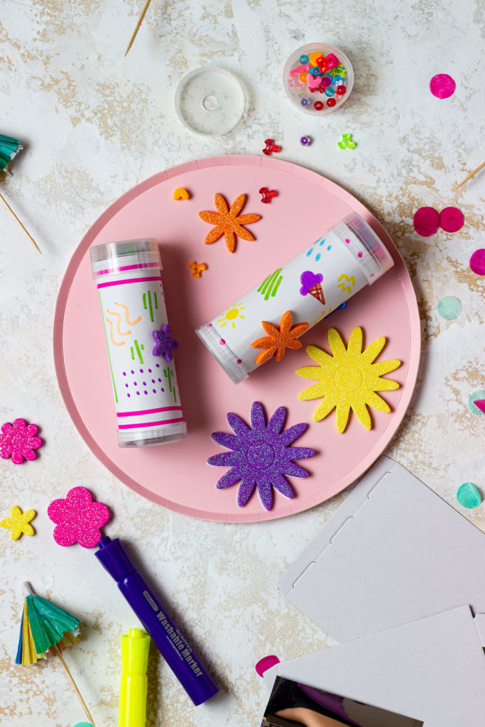 a white kaleidoscope colored in markers and colorful glitter stickers as an activity included in a Memories in Moments Unwrapped box filled with summer themed crafts and activities for kids and busy moms to survive summer break at home