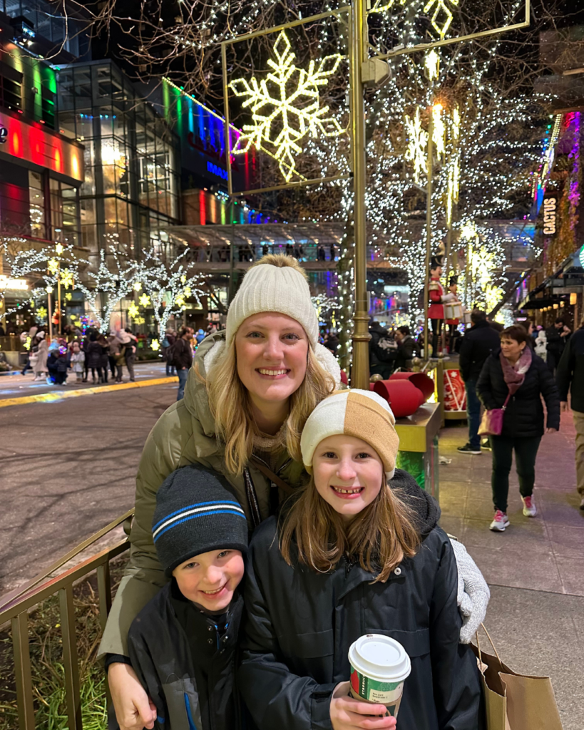 woman at Christmas parade posing with two kids. how to boost engagement and build your brand during holiday season